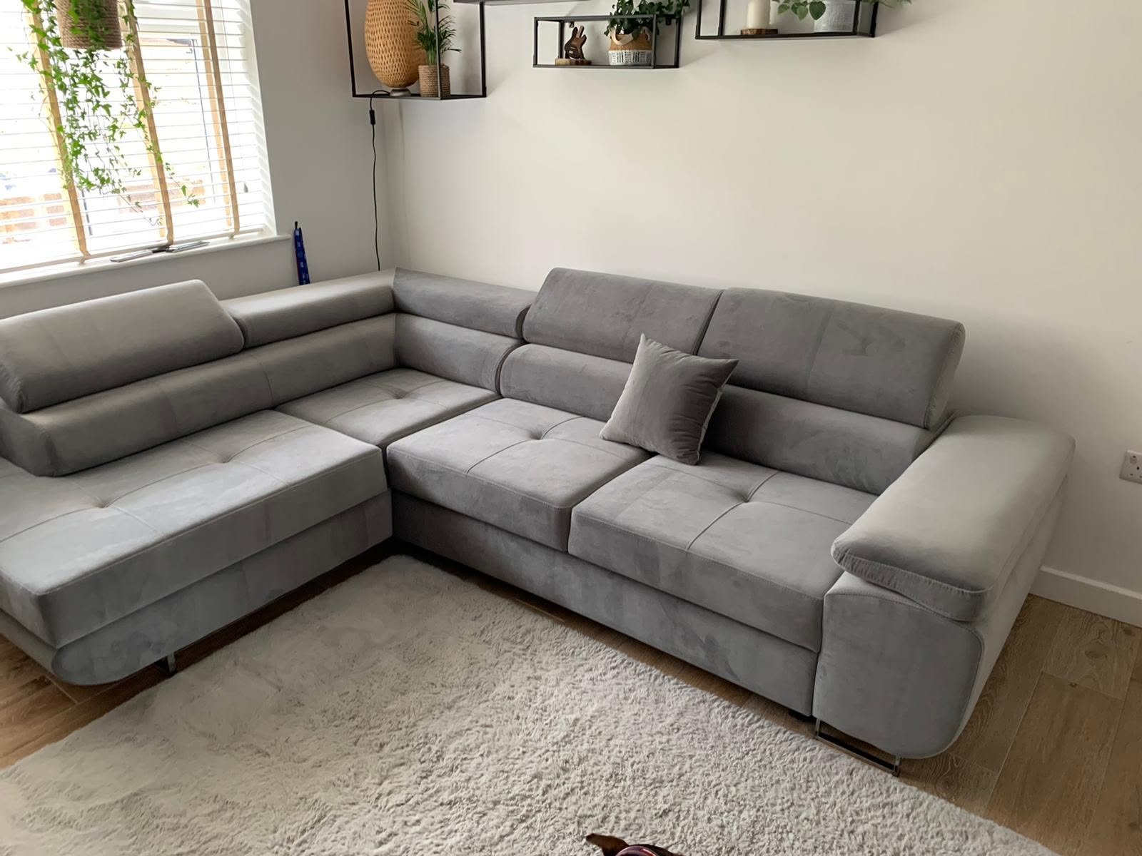 Grey corner sofa bed in a bright living room, customer photo