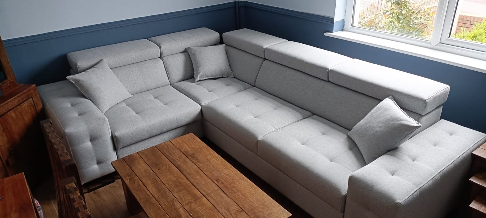 Grey corner sofa bed against a navy wall, customer photo